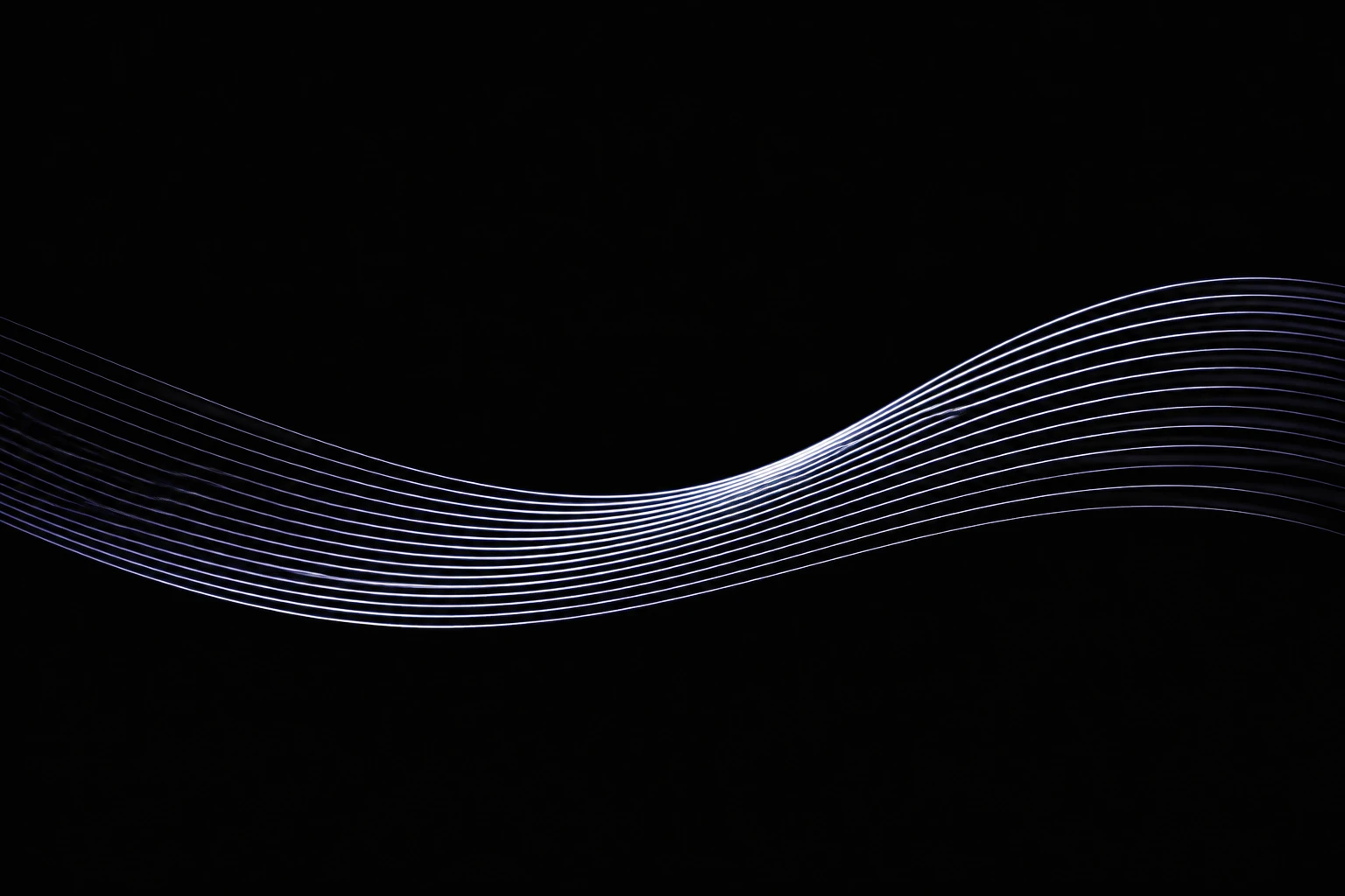 Líneas luminosas que fluyen en una onda continua.